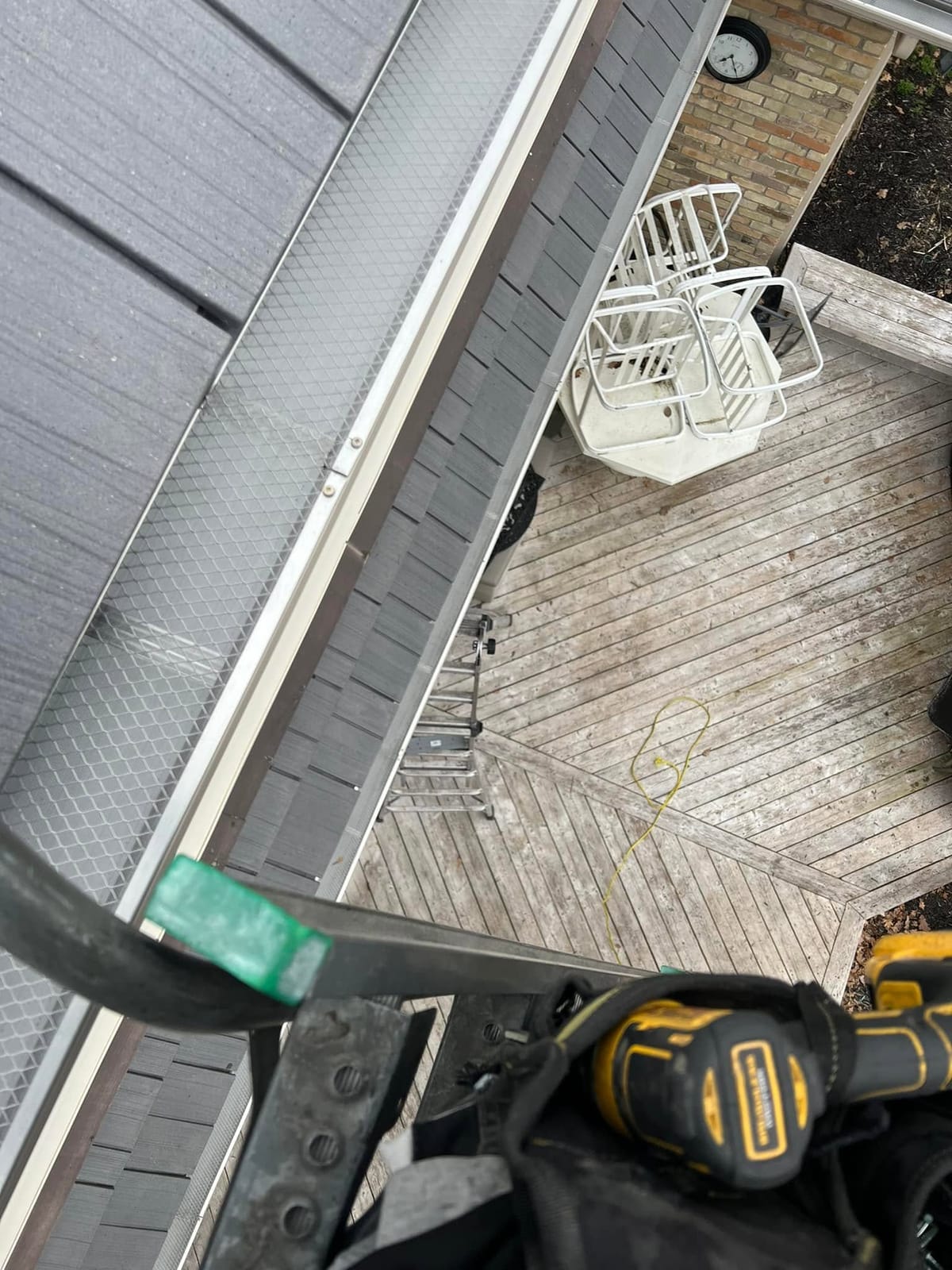 Gutter guards installed on seamless eavestrough, seen from a ladder above a wood deck, in the London, Ontario area