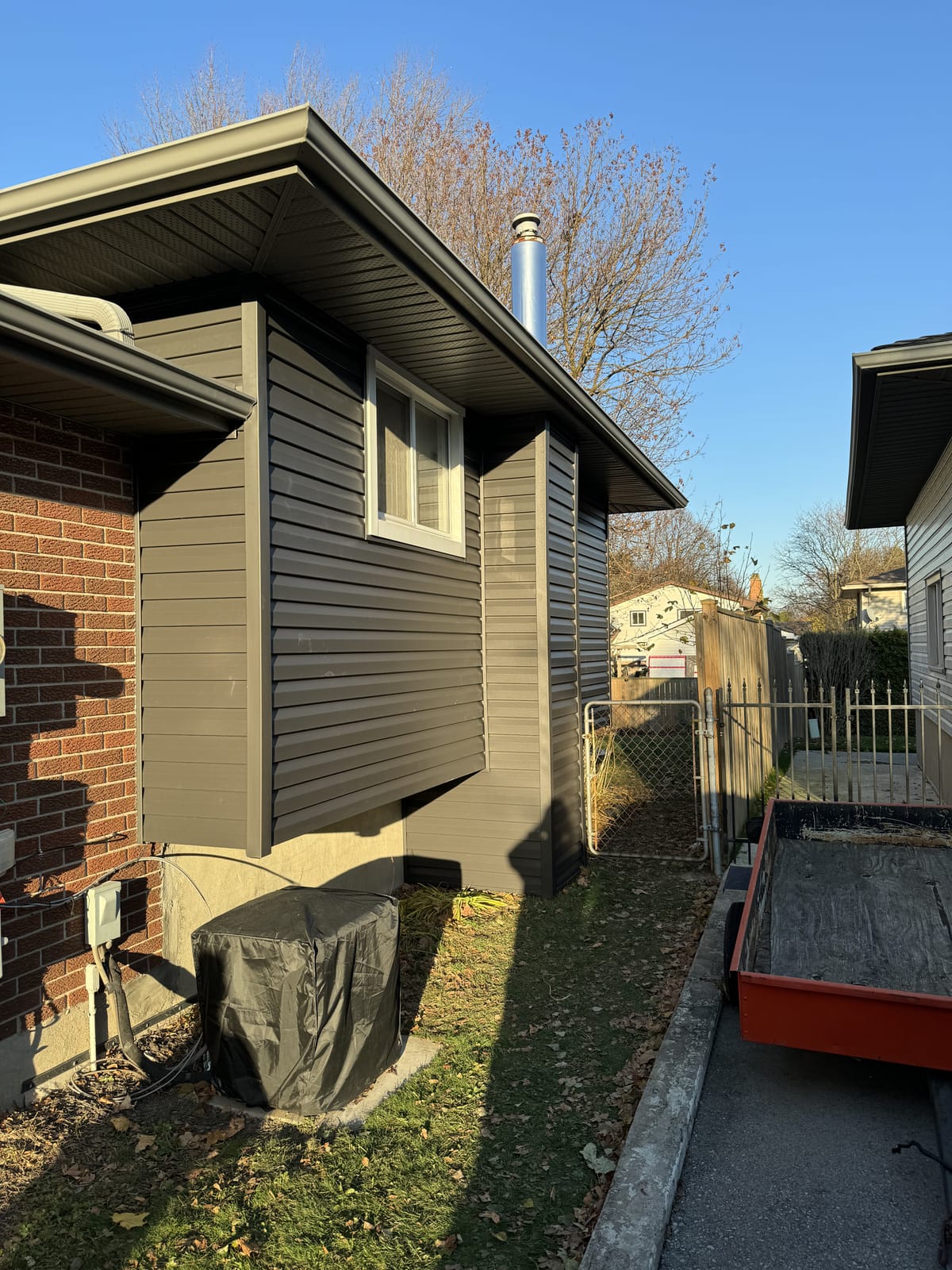 Brown vinyl siding with matching soffit and fascia on the side of a brick home in the London, Ontario area