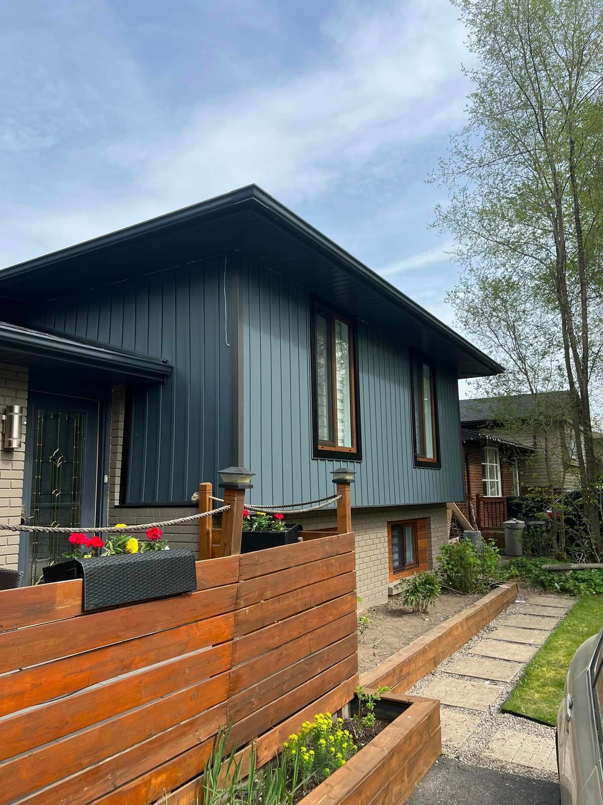 Slate blue vertical vinyl siding with black soffit and fascia on a split-level home in the London, Ontario area