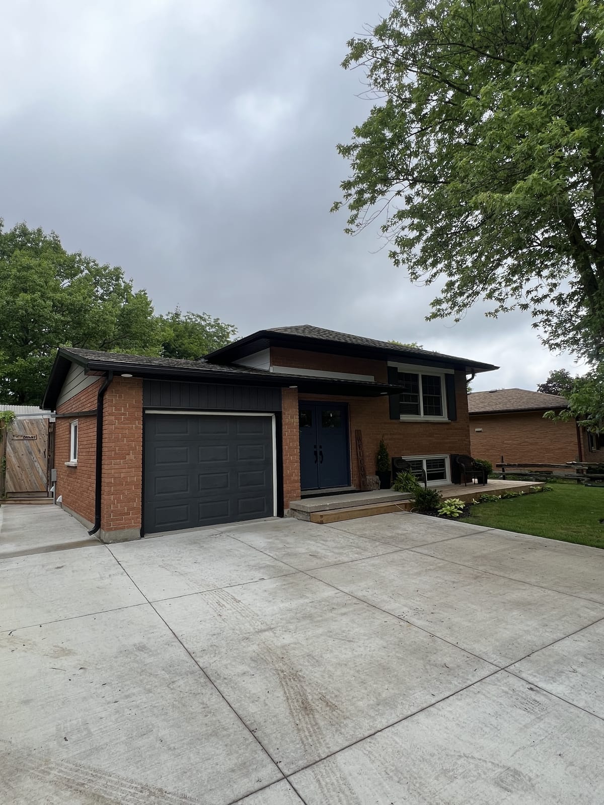 Black seamless eavestrough, soffit and fascia on a red brick split-level home with a dark garage door, London, Ontario area