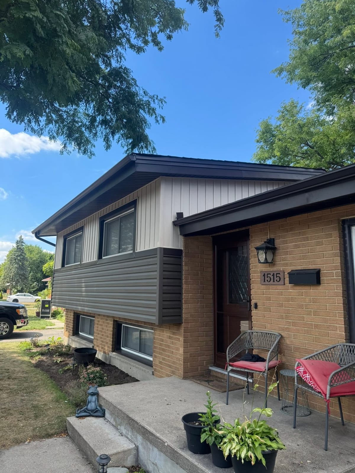 Grey vinyl siding, brown soffit, fascia and seamless eavestrough on a brick split-level home in the London, Ontario area