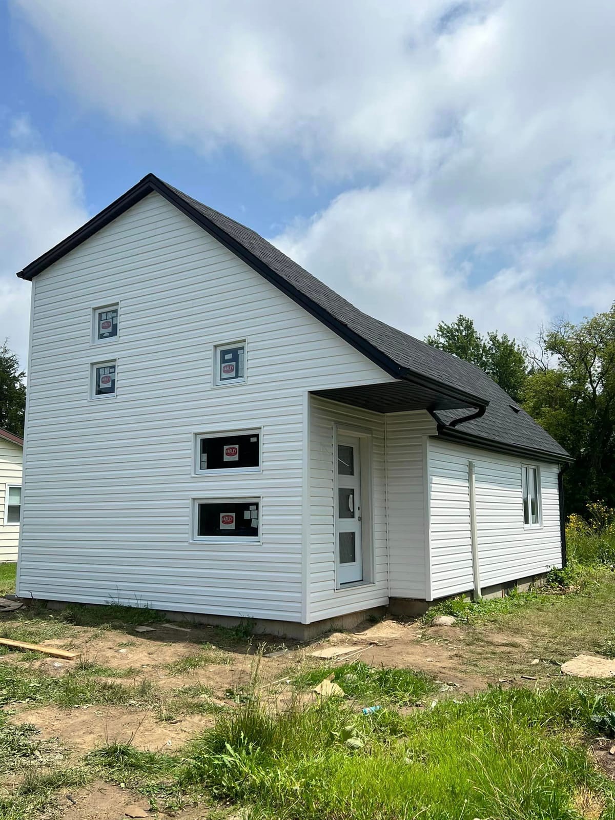 White vinyl siding with black soffit, fascia and seamless eavestrough on a new two-storey home, London, Ontario area