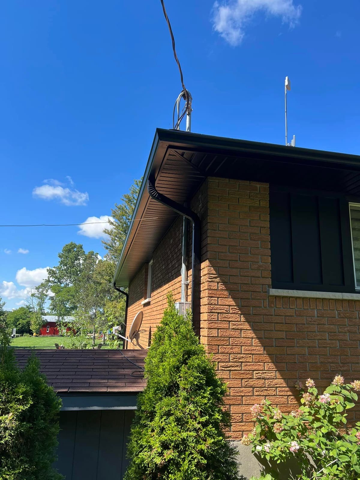 Dark brown seamless eavestrough, soffit and fascia on a yellow-brown brick home in the London, Ontario area