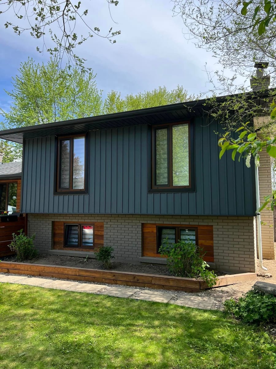 Dark blue vertical board and batten siding with black eavestrough